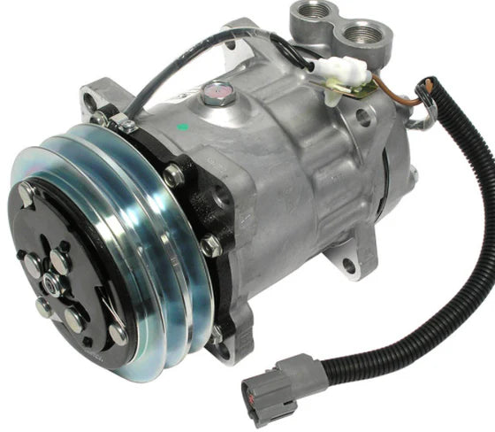 Automann 830.31073 air conditioning compressor 7H15 type, showing the metallic cylindrical compressor with attached hoses.